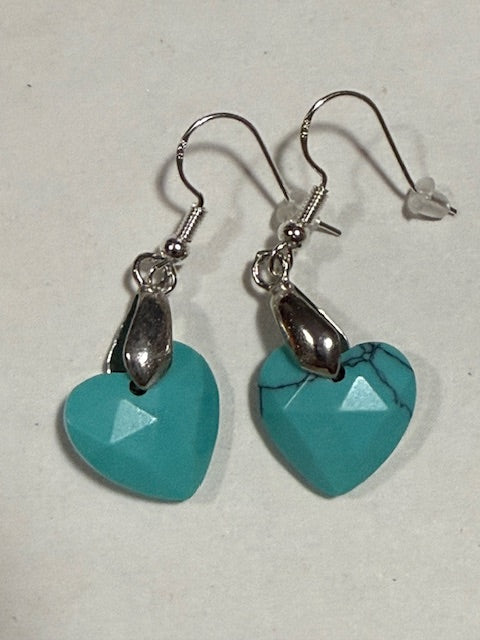 Turquoise heart-shaped earrings with silver hooks on a light background