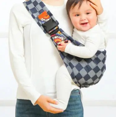 Child being carried in a checkered baby carrier with cartoon characters.