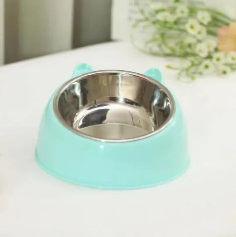 Mint green pet bowl with a stainless steel interior on a white surface.