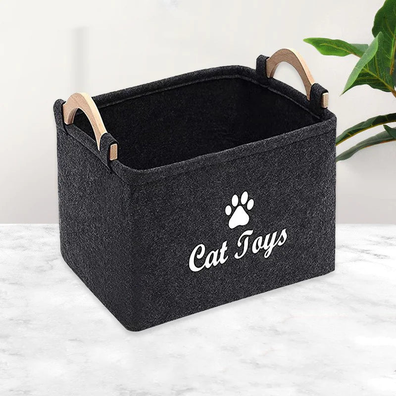 Black storage bin with wooden handles and 'Cat Toys' text on a light background
