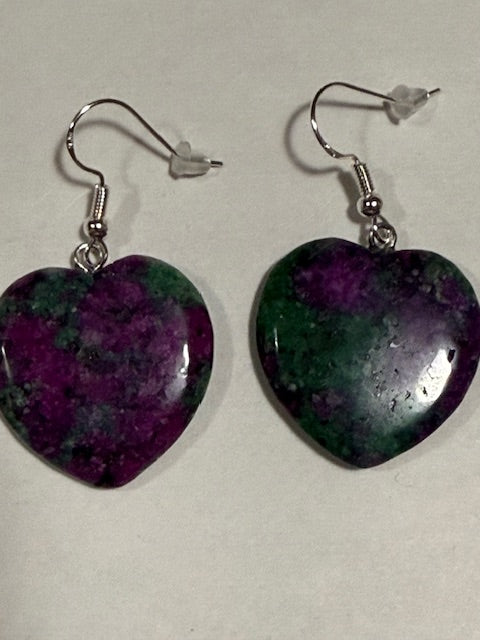Pair of earrings with purple and green marbled stones on a light gray background