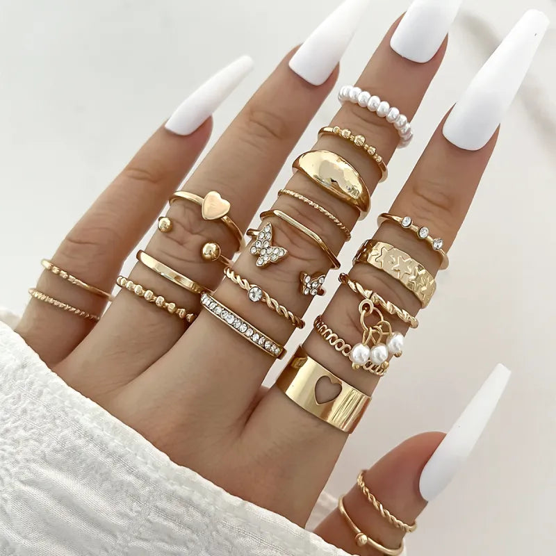 Multiple gold rings on fingers with a neutral background