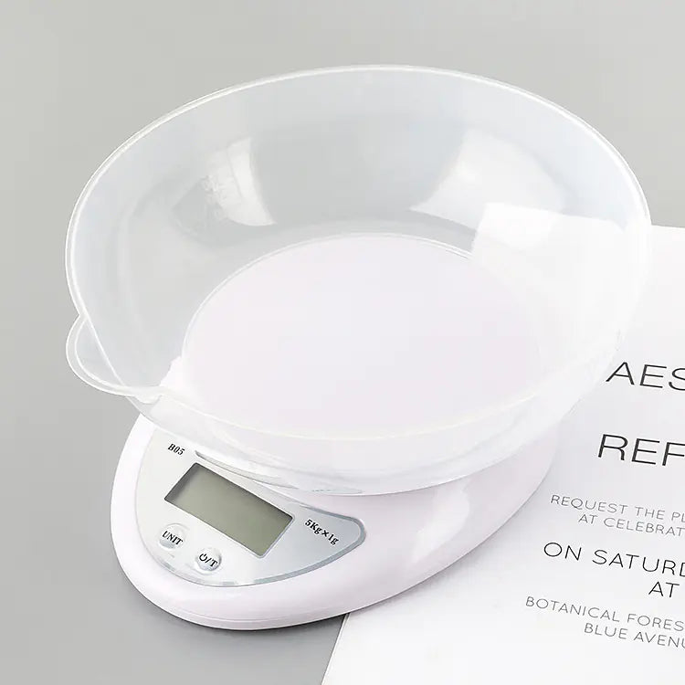 White digital kitchen scale with a clear bowl on a gray background
