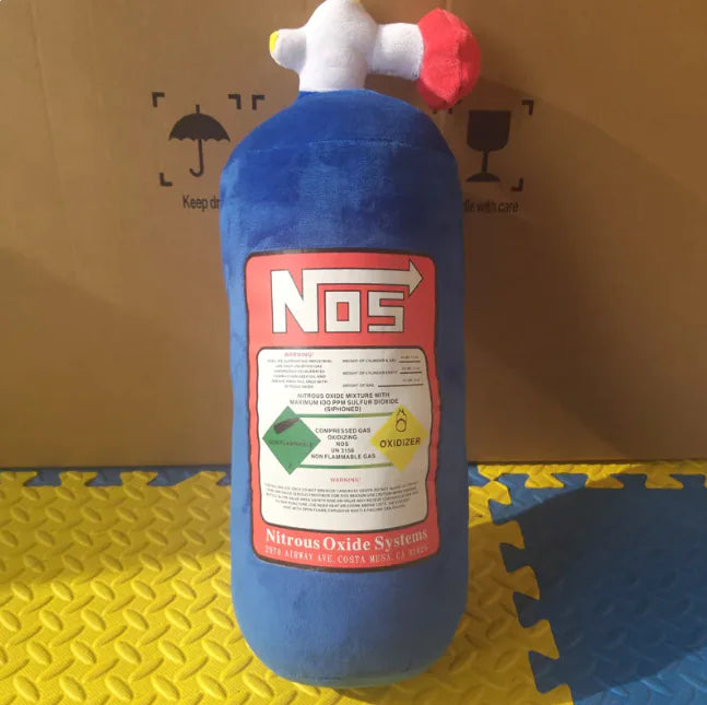 Blue NOS nitrous oxide system canister on a yellow and blue foam mat with a cardboard box in the background.
