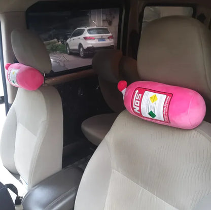 Pink NO3 bottle-shaped cushions on car seats with a car exterior view.