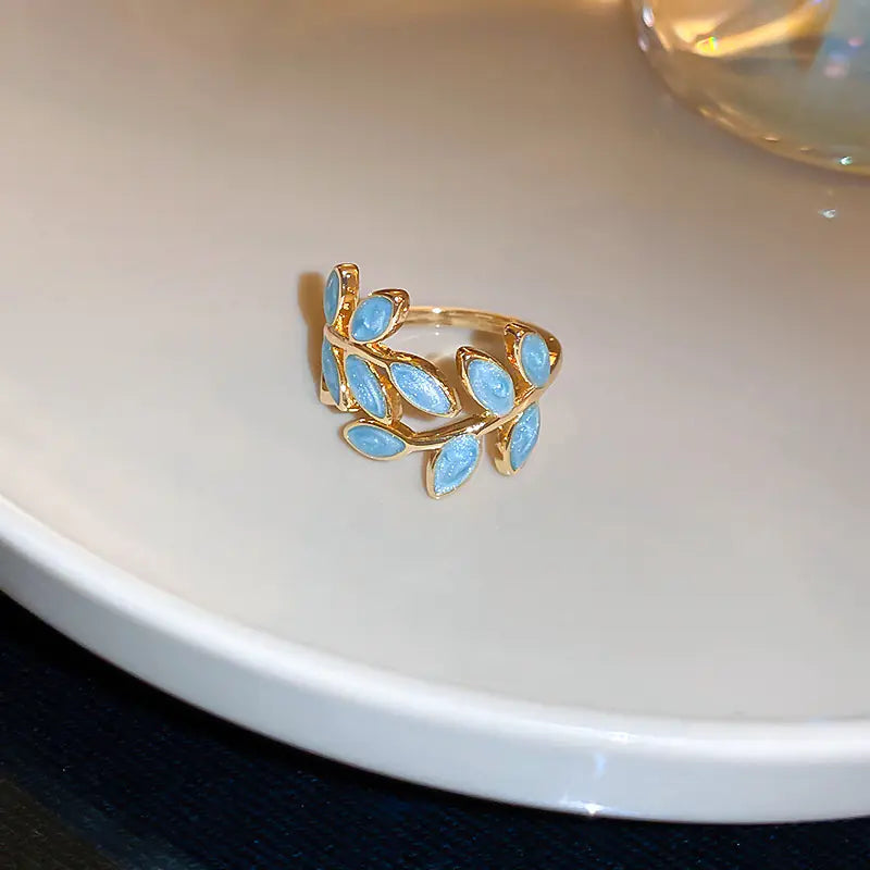 Gold ring with blue gemstones on a white surface