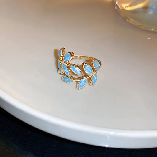 Gold ring with blue gemstones on a white surface
