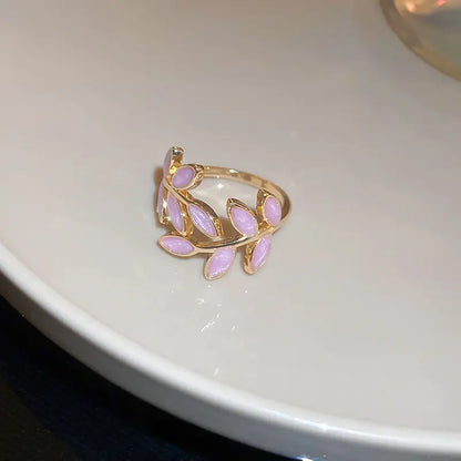 Gold ring with pink stones on a white surface